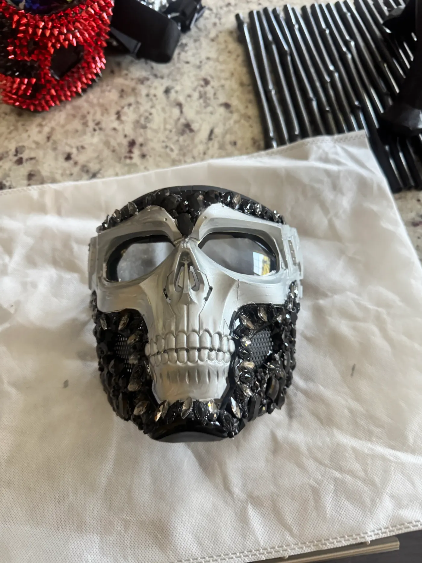 Black crystal embellished skull riding mask on a studio worktable
